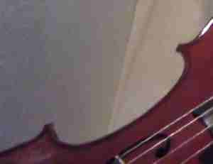 Violoncello on side with wall strings fabric in background
